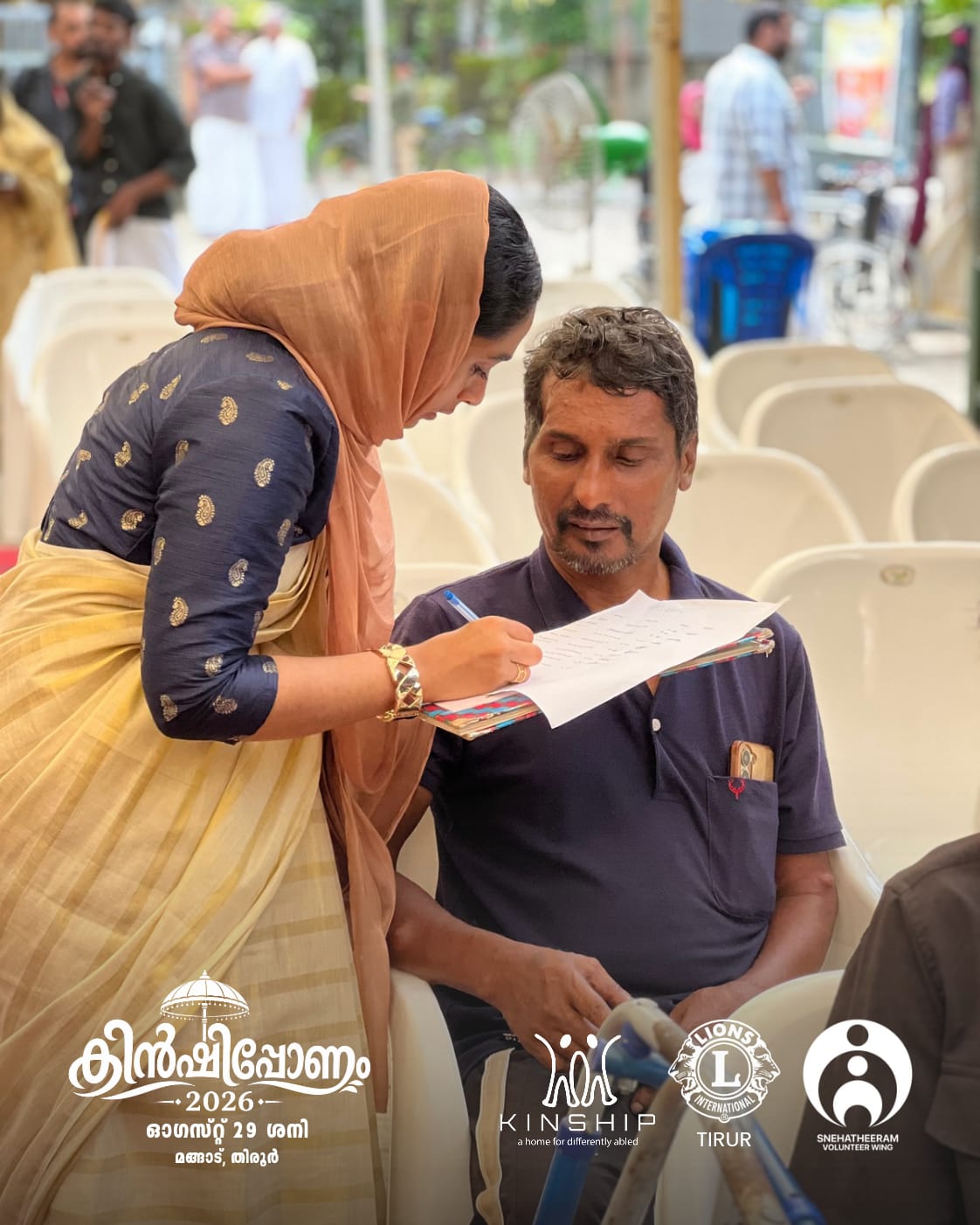 A volunteer assisting a participant during an Onam activity